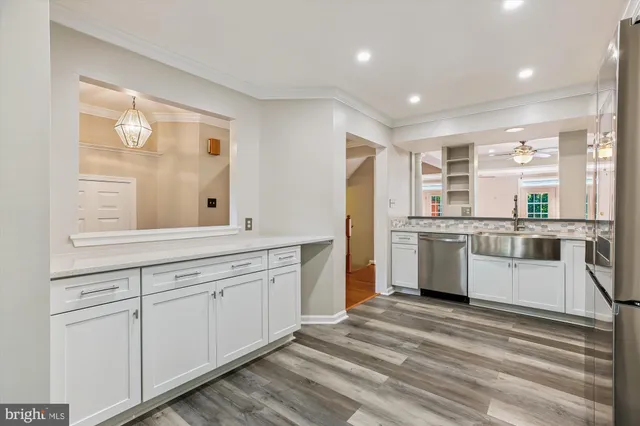 a view of an empty room with wooden floor and a bathroom