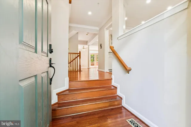 a view of a livingroom with wooden floor and a ceiling fan