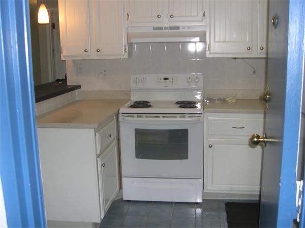 247 Washington, Unit 9 Winthrop, MA 02152 - Photo 5 of 19 a kitchen with granite countertop white cabinets and white stove