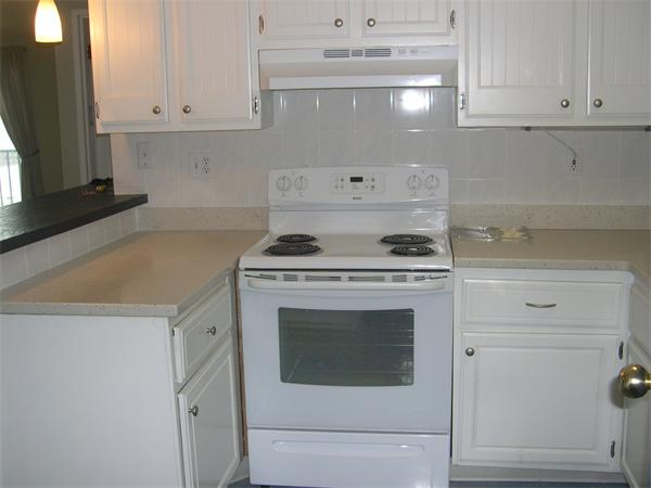 247 Washington, Unit 9 Winthrop, MA 02152 - Photo 6 of 19 a kitchen with white cabinets and white appliances