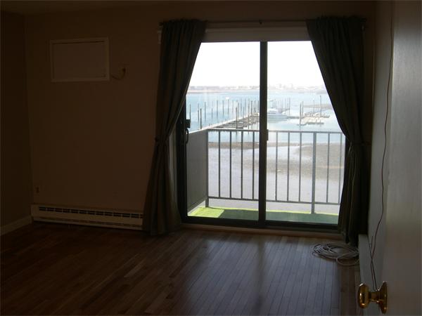 247 Washington, Unit 9 Winthrop, MA 02152 - Photo 10 of 19 a view of empty room with wooden floor and fan