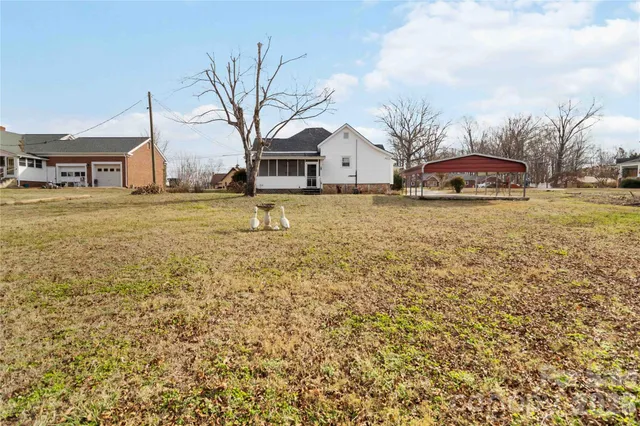 a front view of a house with a yard covered with trees