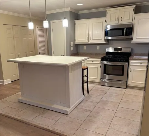 a kitchen with stainless steel appliances a stove a sink a microwave and cabinets
