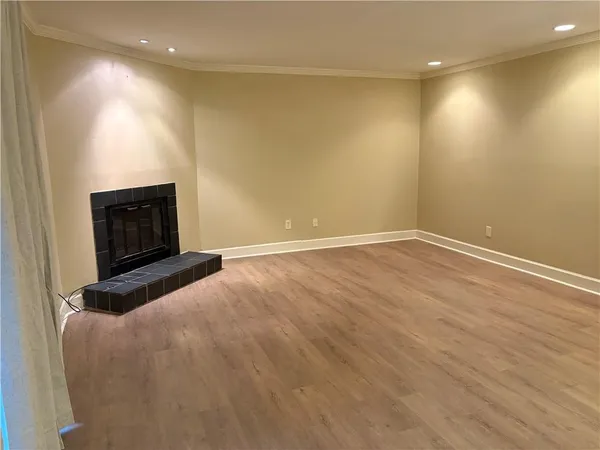 a view of empty room with wooden floor and fireplace