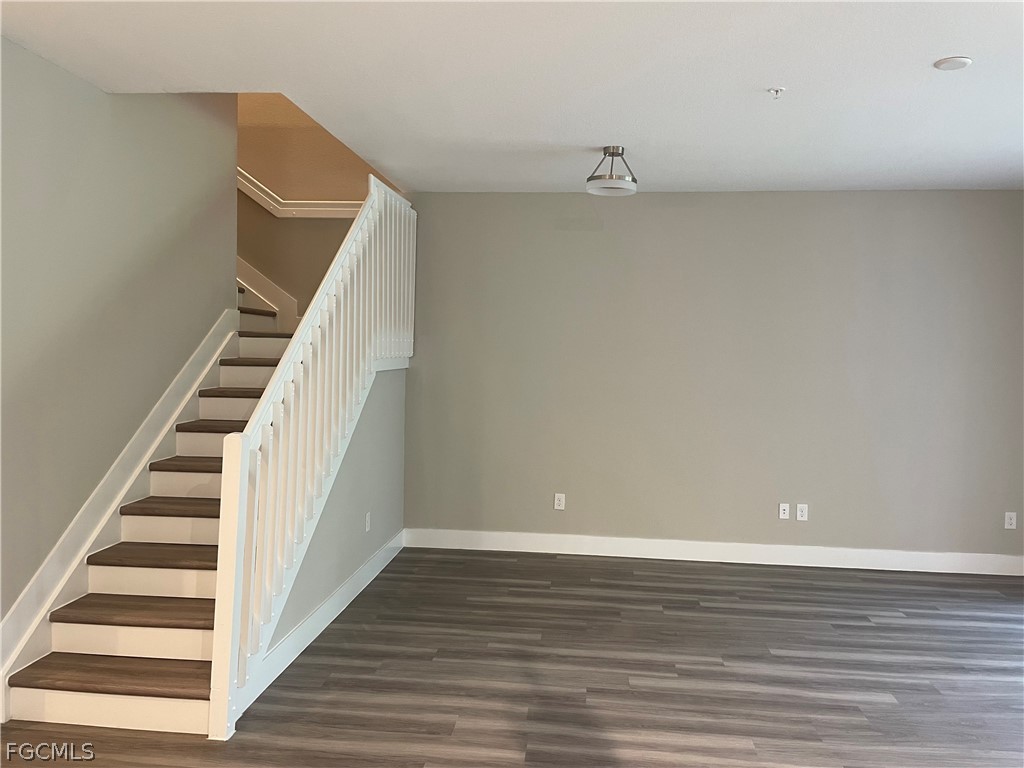 7030 Torino Terrace, Unit 2402 Naples, FL 34119 - Photo 4 of 7 a view of an empty room with wooden floor and stairs