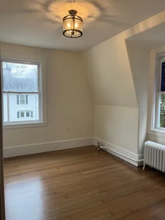 a view of a room with wooden floor and window