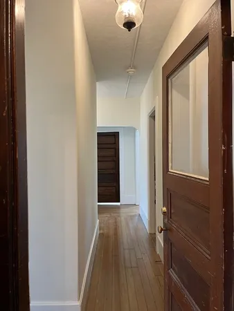 a view of a hallway with wooden floor and staircase