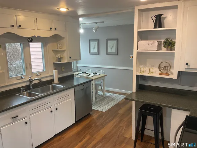 a kitchen with granite countertop a sink stove and cabinets
