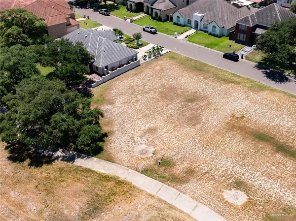 an aerial view of a house with a yard and mountains