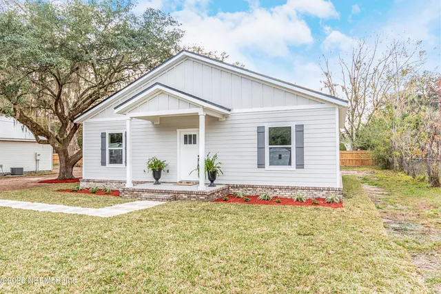 a white house that has a tree in front of it