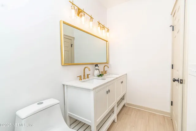 a spacious bathroom with a toilet sink and mirror