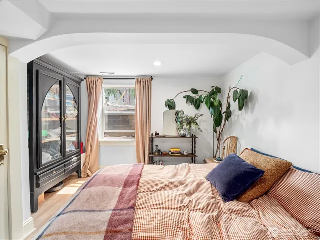 a bedroom with a large bed and a potted plant