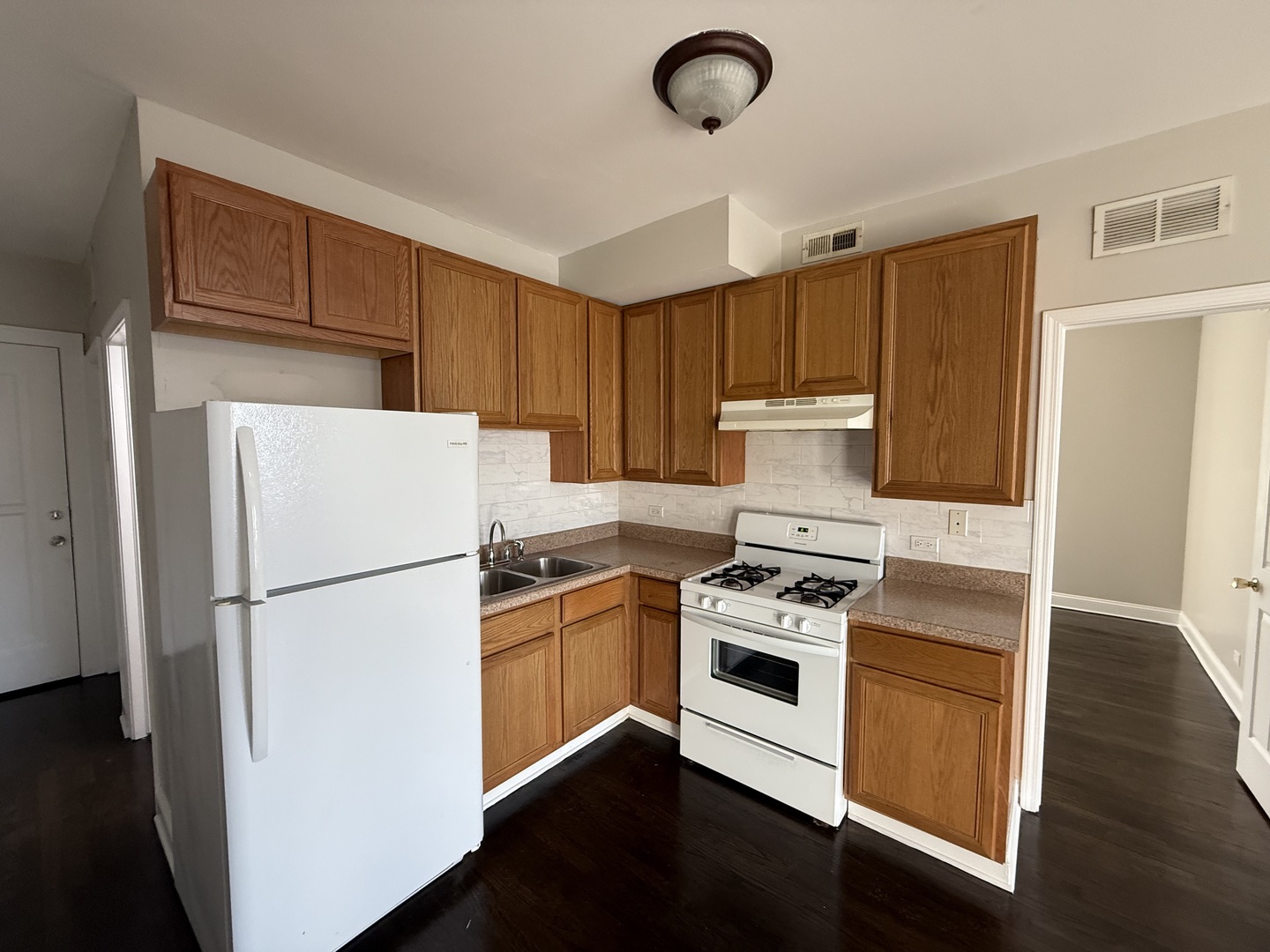 6626 Cermak Road, Unit 1F Berwyn, IL 60402 - Photo 5 of 12 a kitchen with a refrigerator a stove top oven and cabinets
