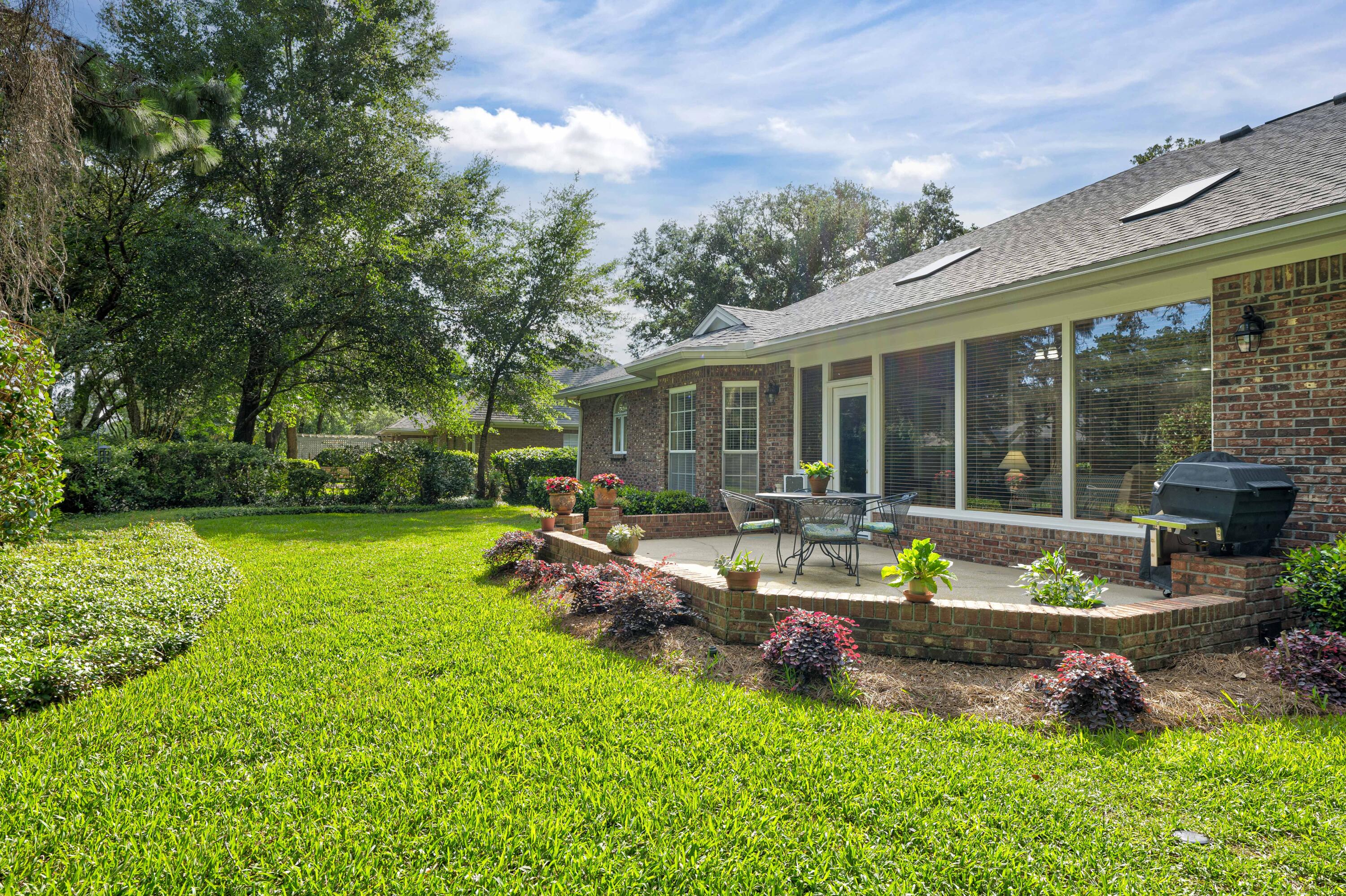 4418 Windrush Drive Niceville, FL 32578 - Photo 18 of 66 a view of a house with backyard sitting area and garden