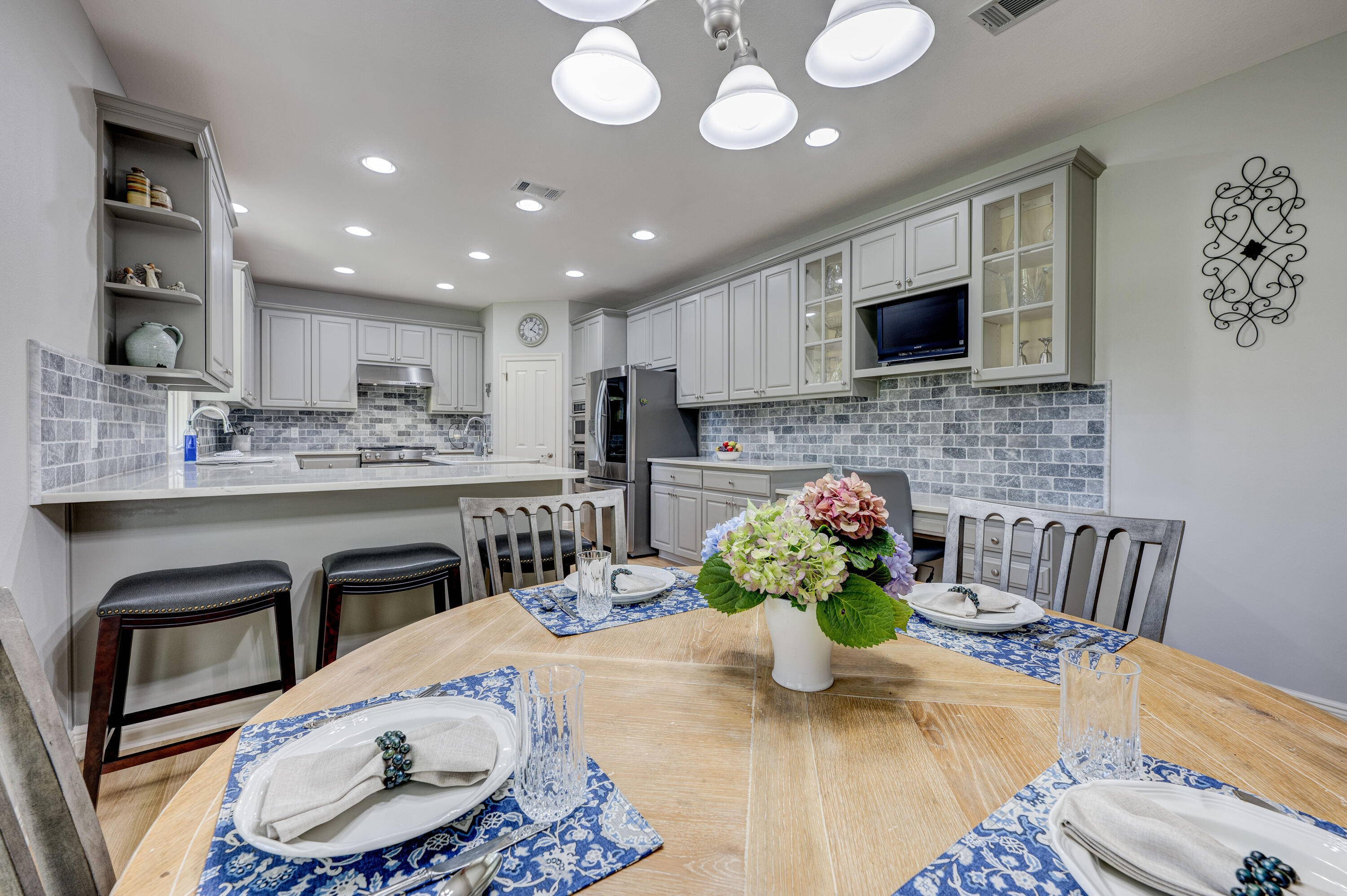 4418 Windrush Drive Niceville, FL 32578 - Photo 23 of 66 a kitchen with stainless steel appliances kitchen island granite countertop a stove a sink dishwasher and white cabinets with wooden floor