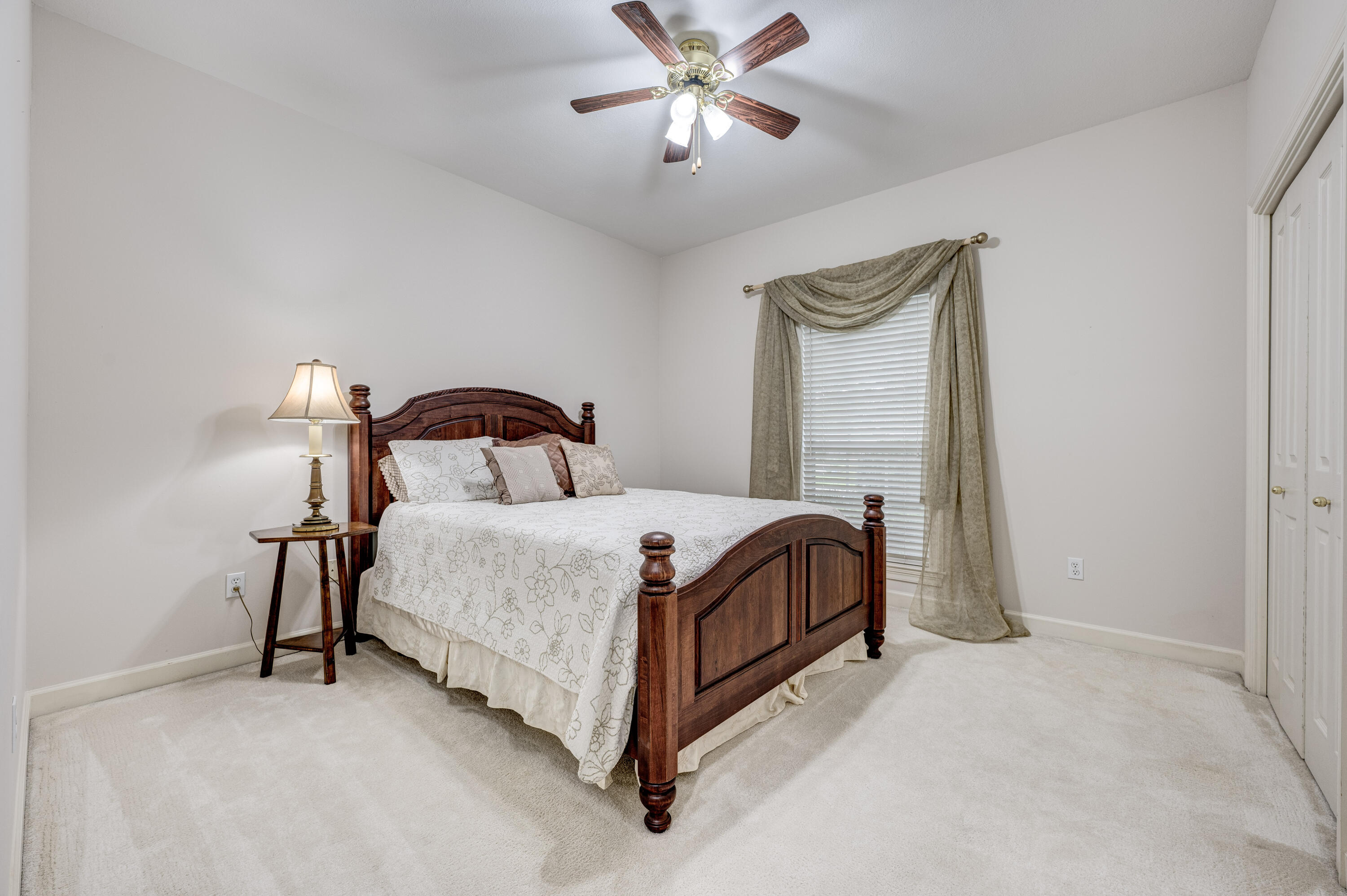4418 Windrush Drive Niceville, FL 32578 - Photo 46 of 66 a bedroom with a bed lamp and a table