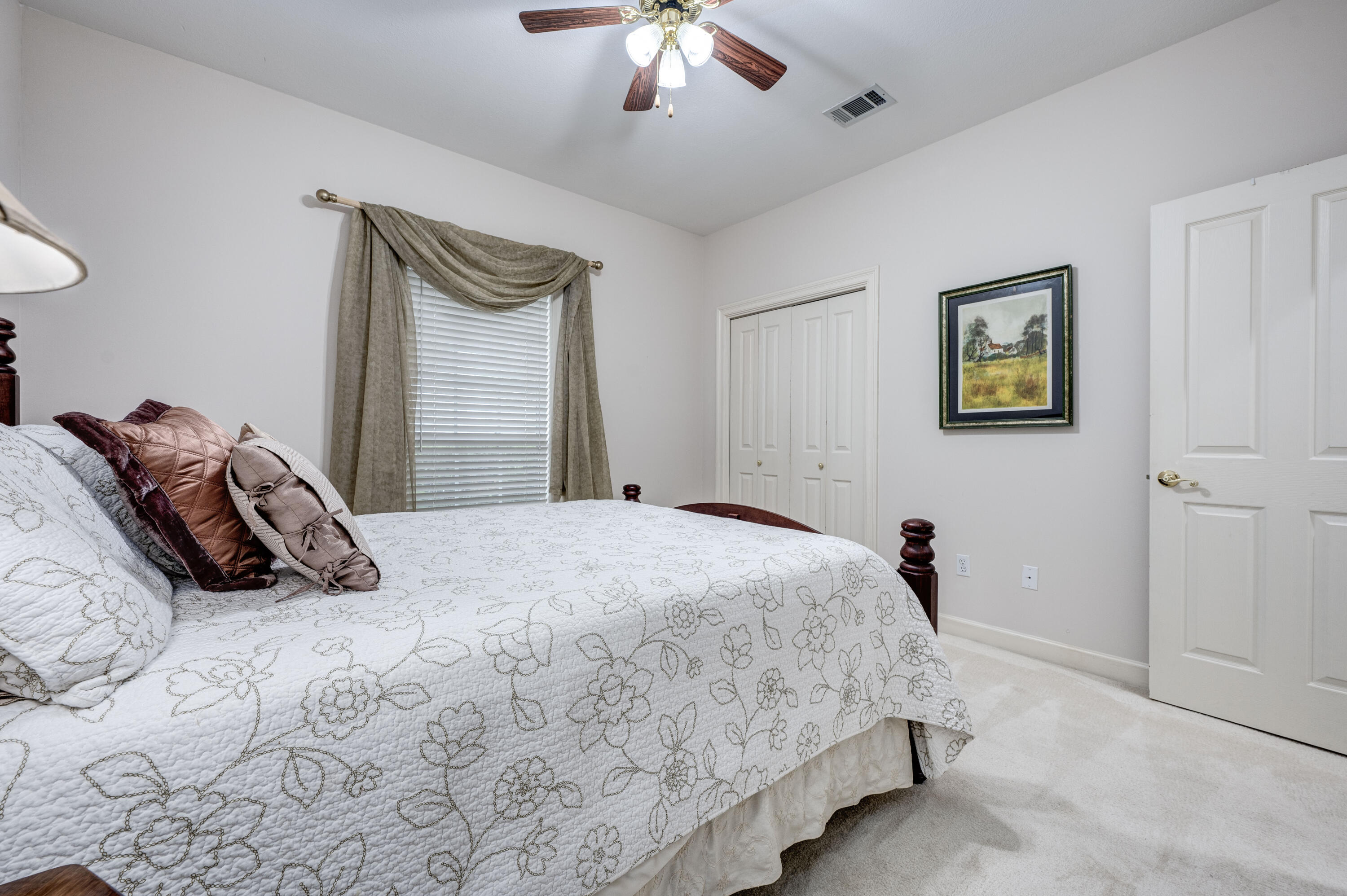 4418 Windrush Drive Niceville, FL 32578 - Photo 47 of 66 a bedroom with a bed and a chandelier