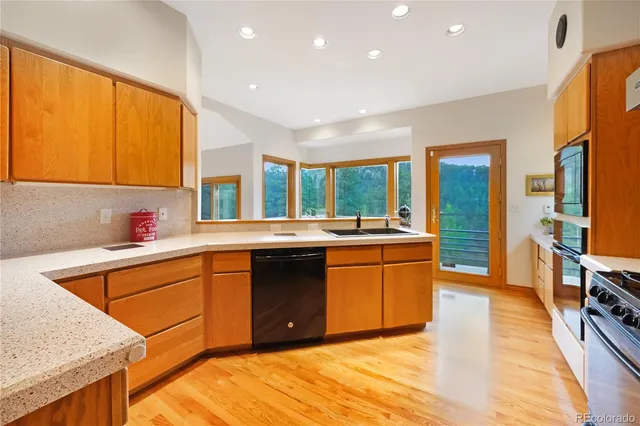 a large kitchen with stainless steel appliances granite countertop a sink and cabinets