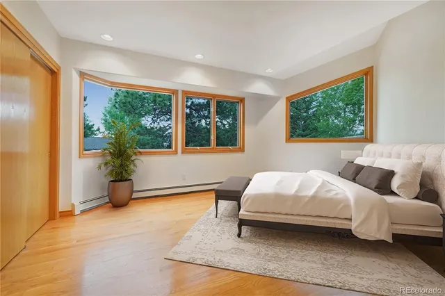 a bedroom with a bed and large windows