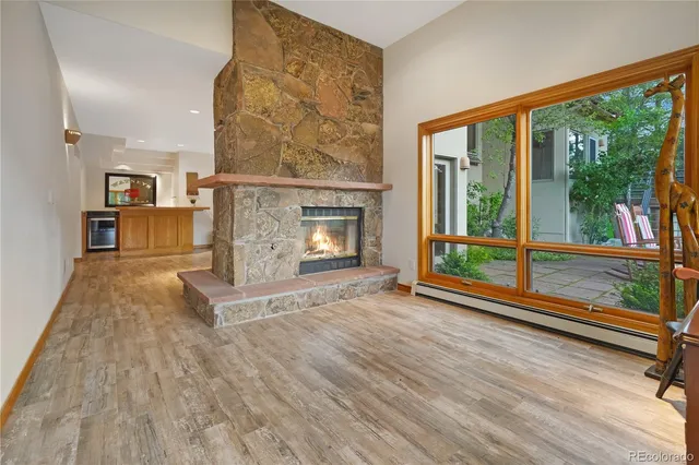 a view of a livingroom with furniture wooden floor windows and a fireplace