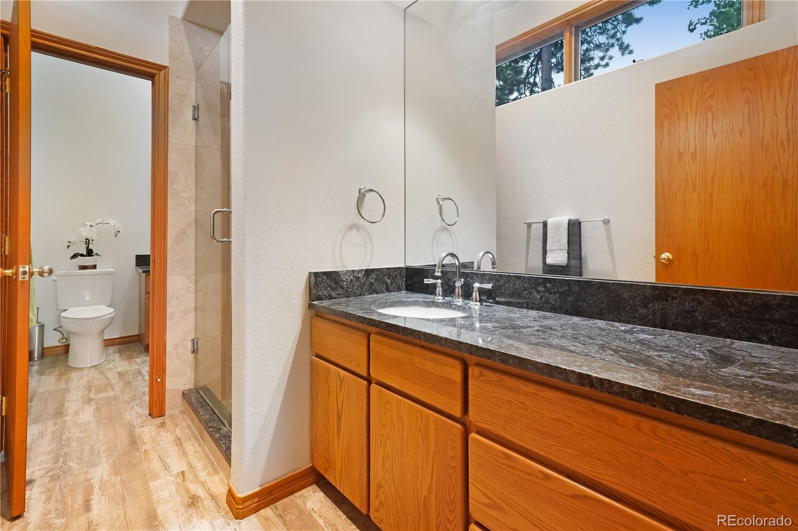 2398 Bitterroot Lane Golden, CO 80401 - Photo 27 of 34 a bathroom with a granite countertop sink and a mirror