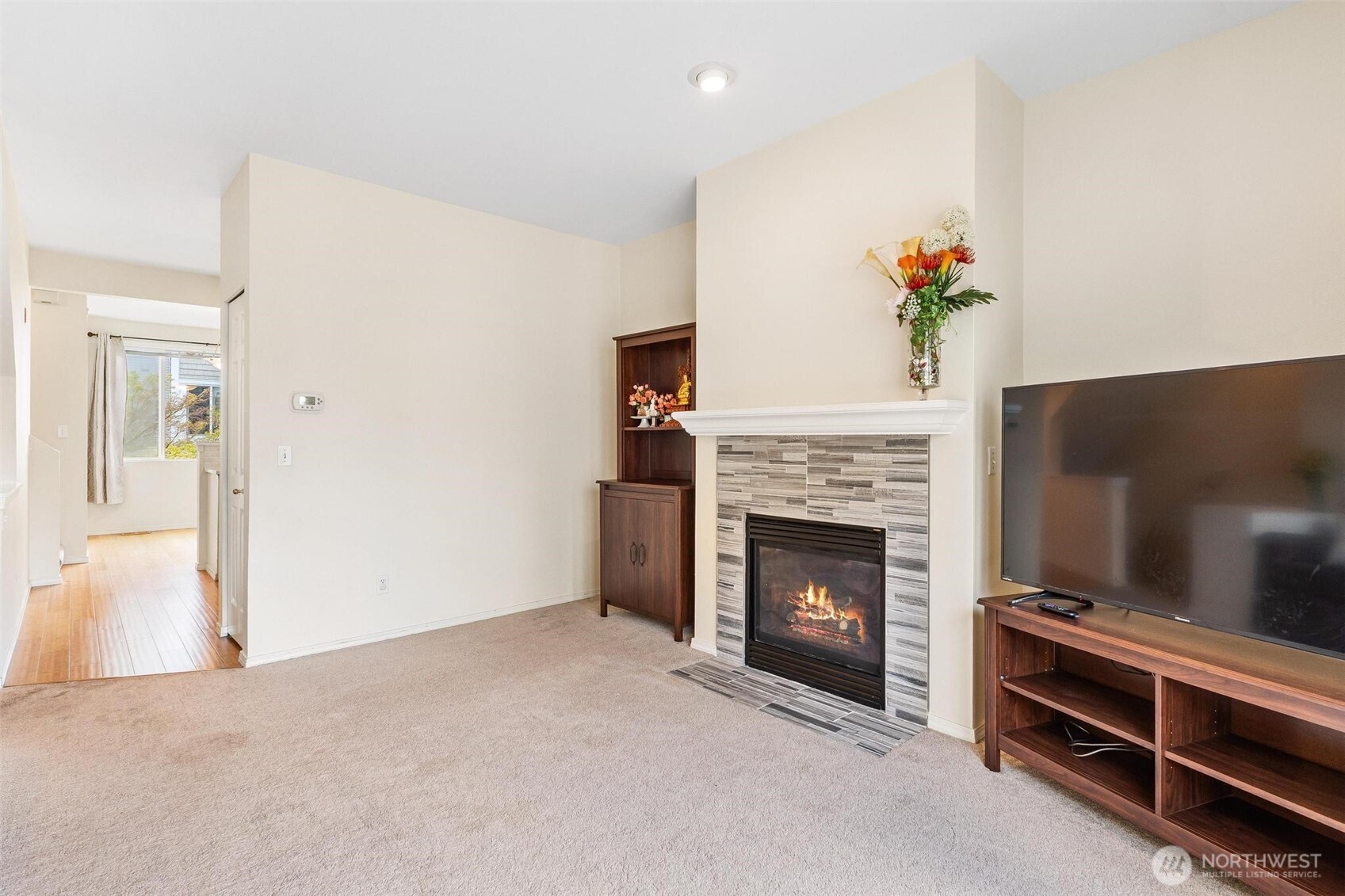 11856 Northeast 162nd Lane, Unit 94 Bothell, WA 98011 - Photo 4 of 36 a living room with a fireplace and a flat screen tv