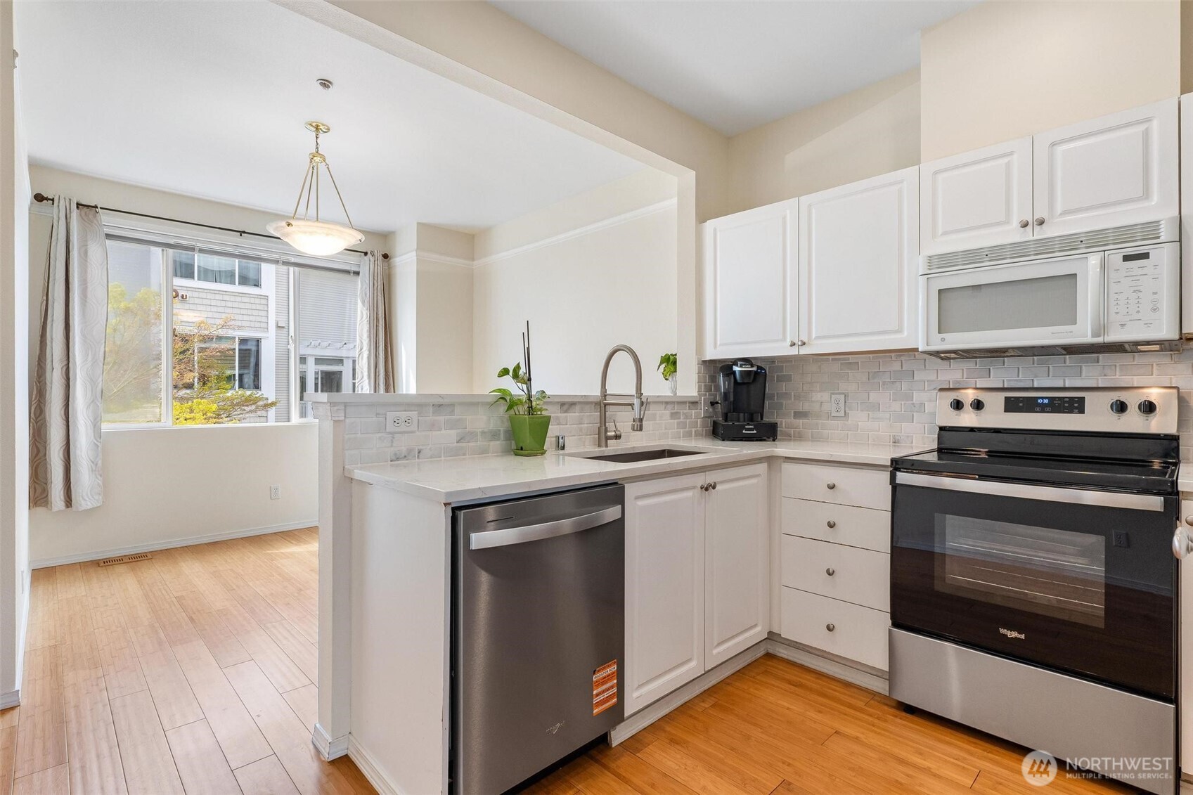 11856 Northeast 162nd Lane, Unit 94 Bothell, WA 98011 - Photo 6 of 36 a kitchen with granite countertop wooden floors appliances and cabinets