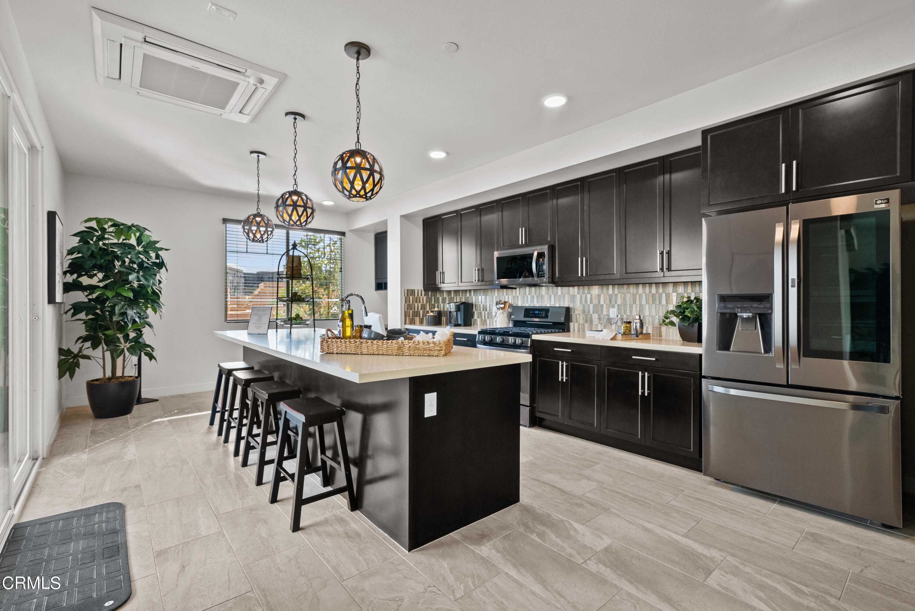 2840 Wagon Wheel Road, Unit 303 Oxnard, CA 93036 - Photo 9 of 26 a kitchen with stainless steel appliances granite countertop a refrigerator a sink dishwasher a stove and a dining table with wooden floor