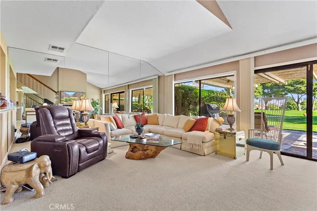 a living room with furniture and a large window with balcony view