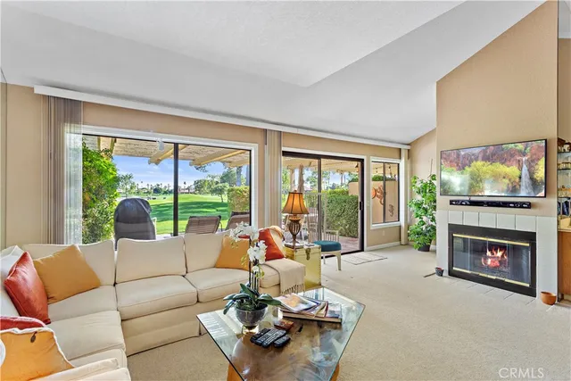 a living room with furniture a floor to ceiling window and a fireplace