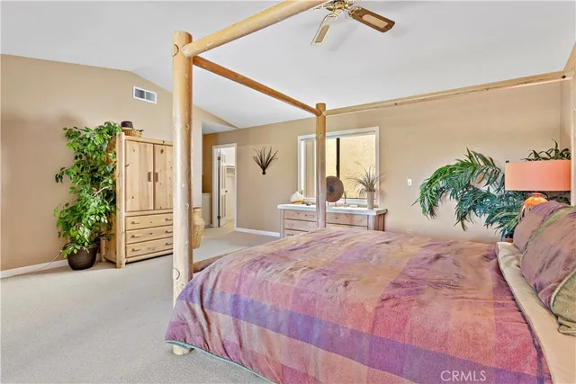 a bedroom with a large bed and a potted plant