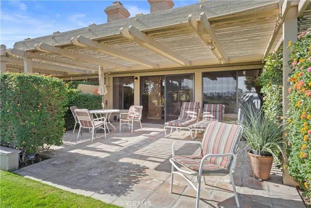 a view of a patio with a table and chairs under an umbrella