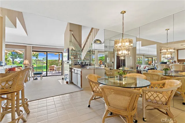 a dining room with furniture a chandelier and wooden floor