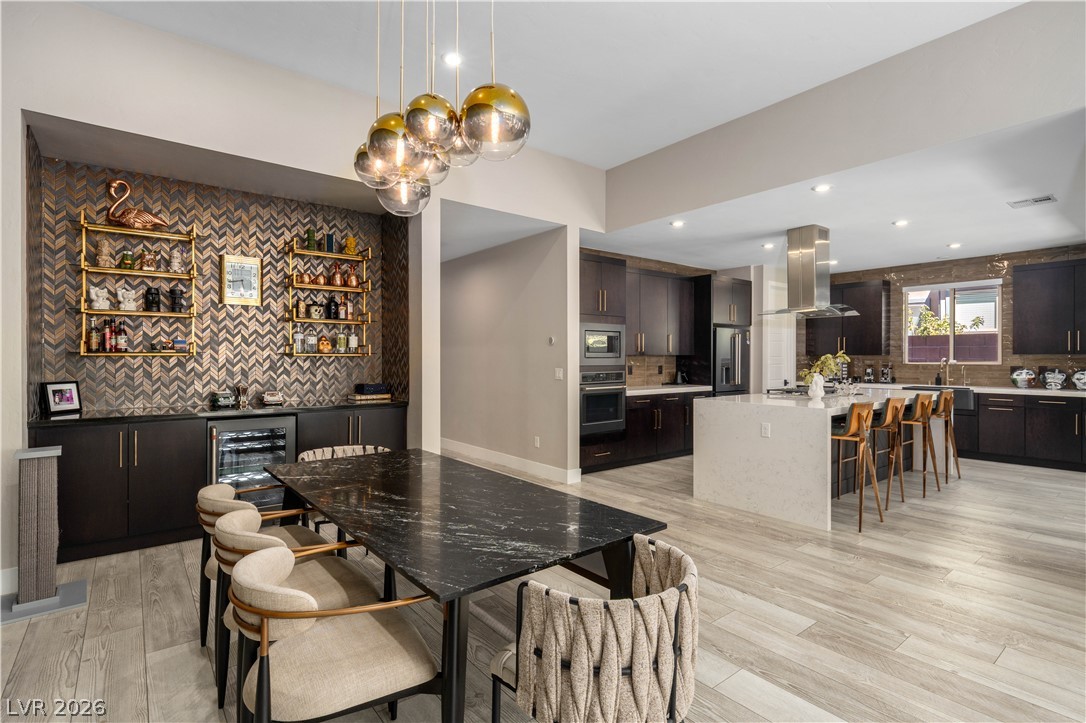 9719 Starlight Ridge Avenue Las Vegas, NV 89148 - Photo 10 of 25 An open-concept living space presents a generous dining area alongside a modern kitchen.