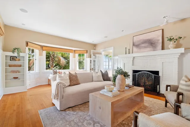 a living room with fireplace furniture and a large window