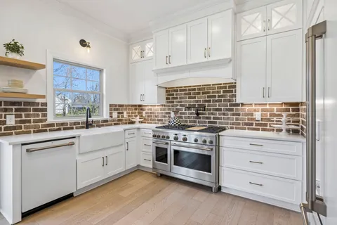 a kitchen with sink a microwave and cabinets