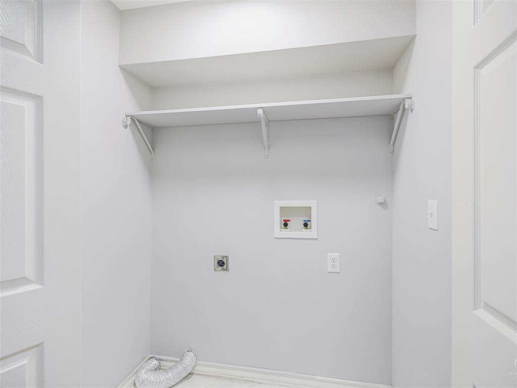 1716 East Parker Road Plano, TX 75074 - Photo 17 of 25 Dedicated laundry area featuring a wall-mounted shelf, utility hookups, and a light-colored wall finish