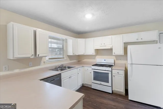 a kitchen with a white cabinets and white appliances