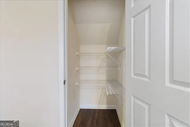 an empty room with wooden floor fireplace and windows