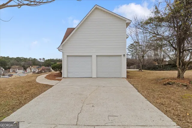 a view of a house with backyard and trees