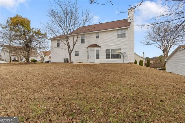 a view of large trees with wooden fence