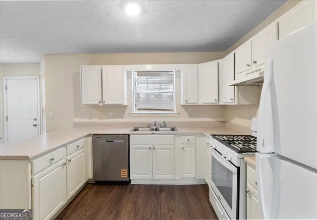 a kitchen with a sink stove cabinets and refrigerator