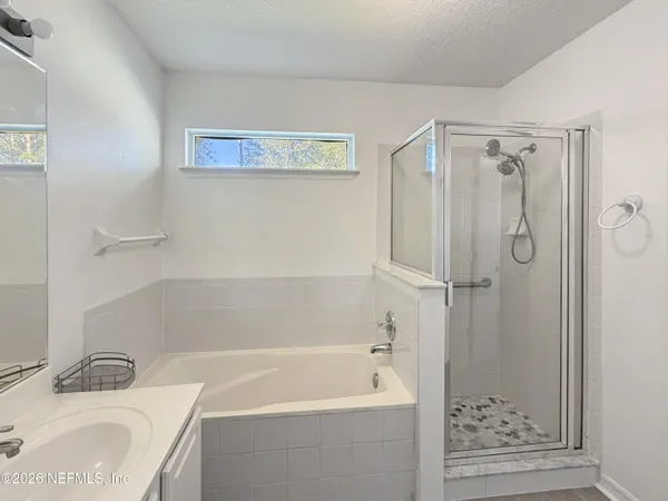 a bathroom with a granite countertop sink a mirror bathtub and shower