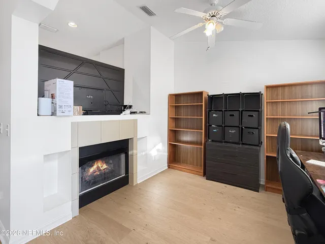 a living room with furniture a fireplace and a ceiling fan