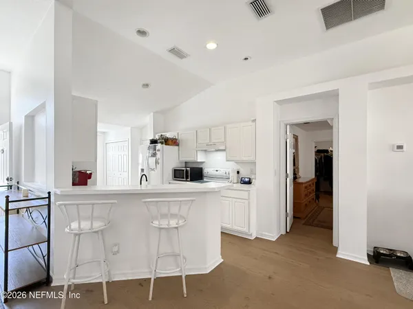 a kitchen with white cabinets and white appliances