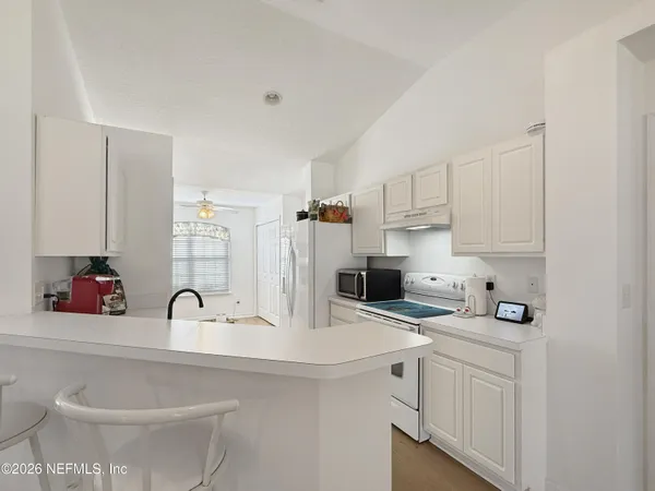 a kitchen with stainless steel appliances a sink a stove and white cabinets