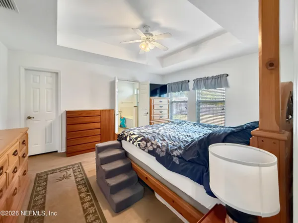 a bedroom with a bed and a dresser with the outer view