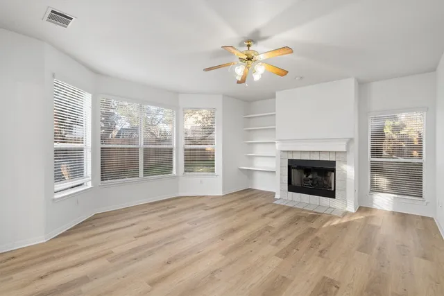 a view of an empty room with a fireplace and a window