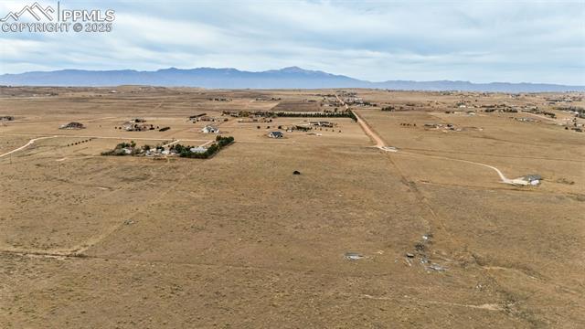 Kennedy Road Peyton, CO 80831 - Photo 2 of 7 Aerial view of sparsely populated area with a mountain backdrop and a desert landscape
