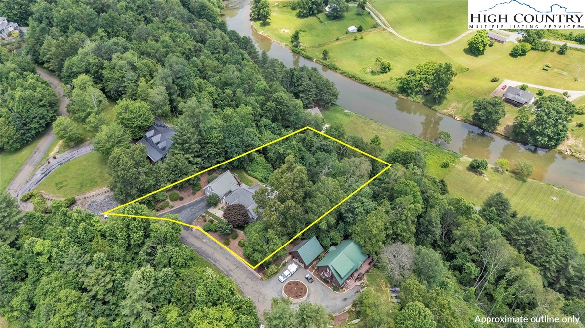an aerial view of a residential houses with yard